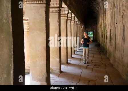 Jeune femme qui se balade dans le complexe archéologique d'Angkor, site du patrimoine mondial de l'UNESCO, Siem Reap, Cambodge, Indochine, Asie du Sud-est, Asie Banque D'Images