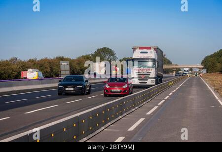 Véhicules passant devant les travaux routiers sur l'autoroute M1, Angleterre. Banque D'Images