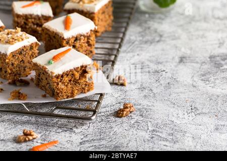 morceaux de gâteau de carotte avec noix et crème glacée sur fond clair. coloration. mise au point sélective/ Banque D'Images