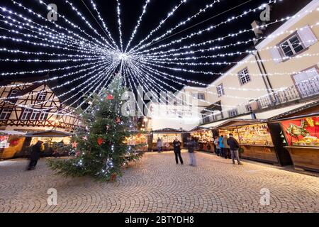 Marché de Noël avec stands illuminés la nuit à la place Fernand Zeyer, Riquewihr, Alsace, France, Europe Banque D'Images