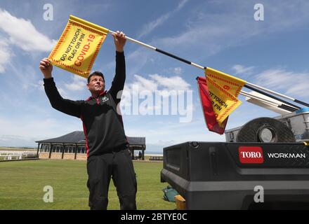 Le gardien de but Simon Connah met des drapeaux sur les poteaux sur l'ancien parcours de St Andrews, à Fife, alors que les préparatifs finaux sont terminés avant la réouverture demain. Le jour où le Premier ministre Nicola Sturgeon a déclaré que les habitants de l'Écosse pourront rencontrer un autre ménage à la fois à l'extérieur à partir de vendredi, à titre de mesures de confinement autour de la facilité pandémique du coronavirus. Banque D'Images