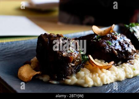 Ossobuco ou osso buco est une spécialité de la cuisine lombarde de jarrets de veau coupés en croix braisés avec des légumes, du vin blanc et du bouillon. Servi avec soit ris Banque D'Images