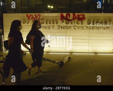 Los Angeles, États-Unis. 27 mai 2020. Deux femmes défilent devant le siège du département de police de Los Angeles, que quelqu'un a étiqueté avec des graffitis qui lisaient '1312 ACAB', un acronyme courant et son code numérique pour 'All COPS are Bastards', lors d'une manifestation dans le centre de Los Angeles, Californie, le mercredi 27 mai 2020. La manifestation, qui faisait partie d'une manifestation nationale, devait montrer l'indignation face à la mort de George Floyd, un homme noir tué lundi lorsqu'un policier blanc de Minneapolis l'a cloué au sol avec son genou. Photo de Jim Ruymen/UPI crédit: UPI/Alay Live News Banque D'Images