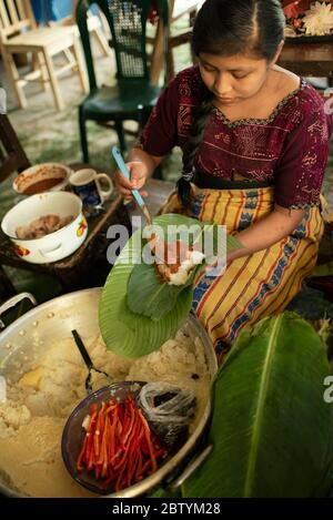 Maya fille de tamales avec de la cosse de maïs, Chili et viande enveloppés dans des feuilles de banane puis cuits dans un grand pot. Tradition guatémaltèque de Noël. Déc 2018 Banque D'Images