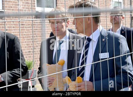 28 mai 2020, Schleswig-Holstein, Neumünster: Daniel Günther (CDU,l), Premier ministre du Schleswig-Holstein, marche avec Dirk Gärtner, Directeur du Bureau d'Etat pour les affaires étrangères, derrière une clôture de protection sur les terrains de l'hébergement. Au cours de la visite, il a annoncé le nouveau nom de l'autorité. À l'avenir, il sera appelé « Bureau de l'immigration et des réfugiés. Photo: Carsten Rehder/dpa Banque D'Images