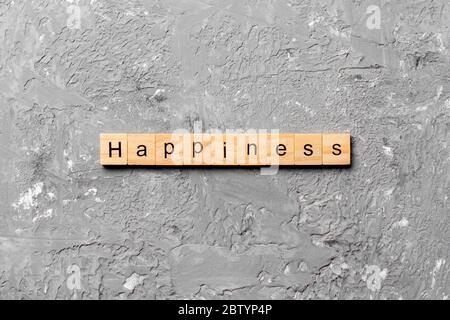 Le bonheur mot écrit sur une cale en bois. Le bonheur texte sur table, concept. Banque D'Images