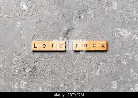 Le mot Rock est écrit sur le bloc de bois. Laisse Rock texte sur la table de ciment pour votre conception, concept. Banque D'Images