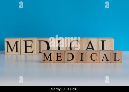 Texte médical en cubes de bois. Fond blanc fond bleu. Studio Banque D'Images