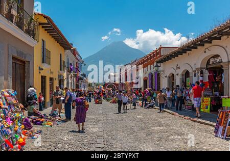 Les gens qui marchent dans la rue principale d'Antigua avec le volcan Agua en arrière-plan, Guatemala. Banque D'Images