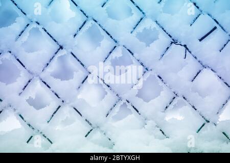 Arrière-plan abstrait en hiver. Neige sur la grille métallique. Banque D'Images