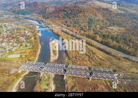 Vue panoramique sur une vallée de montagne avec rivière, village, autoroute et trois ponts en automne. Vue de dessus Banque D'Images