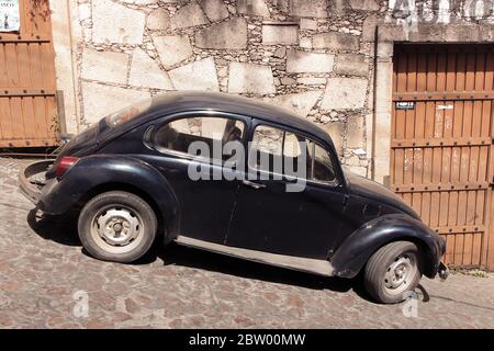 Voiture bleu foncé, Volkswagen, dans la rue abrupte de Taxco, Guerrero, Mexique Banque D'Images