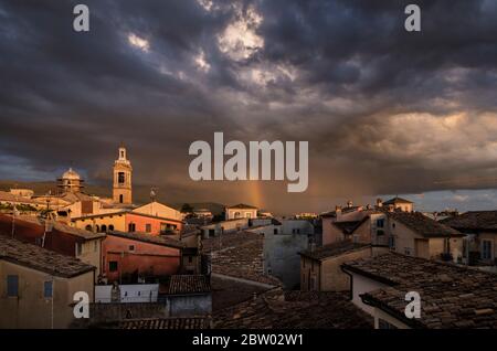 Toits de Foligno pris au soleil, mais mis contre le ciel orageux avec un arc-en-ciel. Ombrie, Italie Banque D'Images