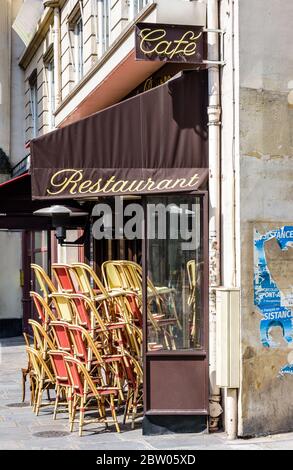 Les chaises en rotin sont empilées devant un café-terrasse parisien qui doit rester fermé pendant la période de confinement en raison de la pandémie COVID-19. Banque D'Images