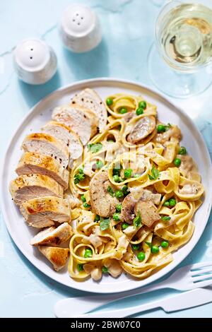 Tagliatelle aux pâtes avec champignons et petits pois et poulet Banque D'Images