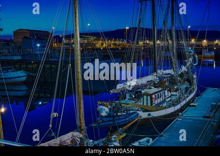 Début de l'été vue de nuit sur le port de Reykjavik, bateaux, lumières dans la lumière bleue de minuit Banque D'Images