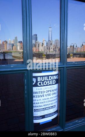 Un bâtiment fermé note à l'intérieur de la fenêtre de l'ancien Central Railroad du New Jersey terminal bâtiment avec le reflet de l'horizon de Lower Manhattan pendant l'épidémie de coronavirus Covid-19.Liberty State Park.New Jersey.USA Banque D'Images