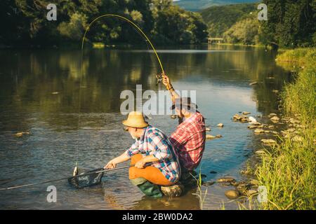 Hommes barbus pêcheurs. Homme le plus heureux. Fishman crocheted spin dans la rivière attendant de grands poissons. Jeune homme pêche. Faites ça seulement. Bon profit. Heureux Banque D'Images