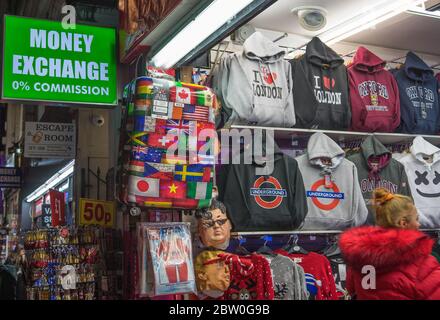 Panneau d'échange d'argent devant une boutique de souvenirs de Londres avec drapeaux du monde et sweats à capuche exposés. Londres Banque D'Images