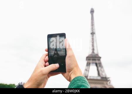 Mains caucasien homme touristique Blogger rend les sites les plus importants Paris France la Tour Eiffel photo à l'aide d'un smartphone Banque D'Images