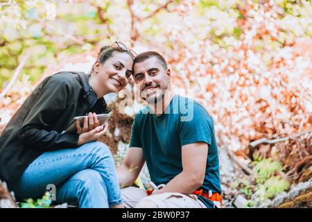 Jeune couple sportif souriant et heureux assis dans un pré dans un parc Banque D'Images