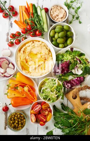 Plat avec deux sauces et en-cas végétariens crus sur table en bois blanc. Banque D'Images