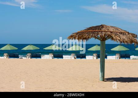 Parasol en paille avec chaises et parasols sur une plage mexicaine Banque D'Images