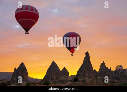 Ballons d'air chaud flottant dans le ciel au lever du soleil Banque D'Images