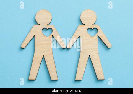 Deux couples homosexuels tiennent les mains sur fond bleu. Banque D'Images