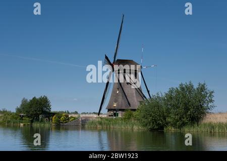 Paysage avec de beaux moulins à vent traditionnels hollandais près des canaux d'eau avec ciel bleu et nuages réfléchissent dans l'eau. Kinderdijk Banque D'Images