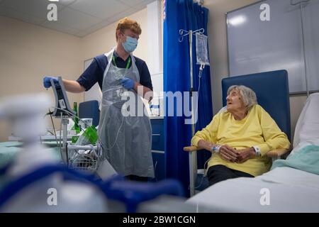 Les travailleurs de Rehab support discutent avec la patiente Shirley Hughes, 86 ans, car les premiers patients sont admis au NHS Seacole Centre de Headley court, Surrey, un hôpital militaire désutilisé, qui a été converti pendant la pandémie du coronavirus. Nommé en l'honneur de l'infirmière née en Jamaïque, Mary Seacole, l'établissement aidera à soigner et à soutenir les patients qui se rétablissent de la COVID-19 et qui n'ont plus besoin de soins dans un hôpital de courte durée, ou ceux qui ont la COVID et qui ne peuvent plus faire face à leurs symptômes à la maison. Banque D'Images