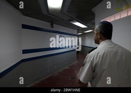 Officier du service pénitentiaire d'Israël communément connu en Israël par son acronyme Shabas ou ISP en anglais marchant le long d'un couloir peint avec le drapeau israélien à l'intérieur de la prison d'Eshel près de Beersheba en Israël Banque D'Images