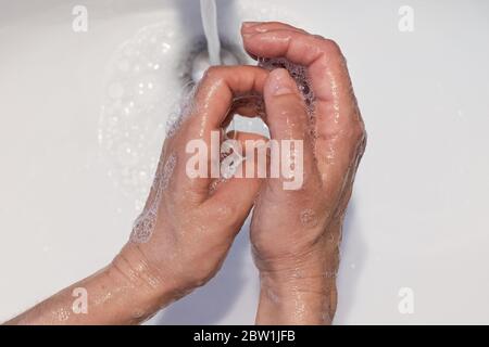 gros plan des mains des femmes lavées dans un lavabo blanc avec du savon, concept de soins de santé, prévention des infections Banque D'Images
