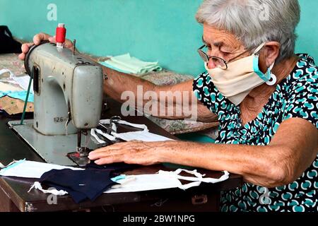 (200529) -- LA HAVANE, 29 mai 2020 (Xinhua) -- Iraida Hernandez utilise une machine à coudre pour fabriquer des masques pour ses proches et voisins à la maison, à la périphérie de la Havane, Cuba, 27 mai 2020. Iraida Hernandez, 87 ans, ne s'attendait pas à retourner à sa vieille machine à coudre à son âge avancé, mais la nécessité de protéger sa famille la replace devant les rouleaux de fils et les coupures de tissu. La femme au foyer, qui vit à la périphérie de la Havane, fait des masques pour protéger ses proches et ses voisins de la COVID-19. Hernandez n'est pas seul. Son fils, Ruben Ruiz, technicien en construction civile, est également ma Banque D'Images