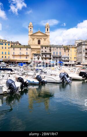 Vue sur l'église Saint-Jean-Baptiste à Bastia depuis le vieux port avec quelques bateaux reposant dans le port pendant l'été Banque D'Images