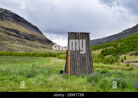 Petite cabane en rondins islandais sans fenêtres, dans un pré à côté des montagnes. Sans murs. Toit uniquement. Banque D'Images