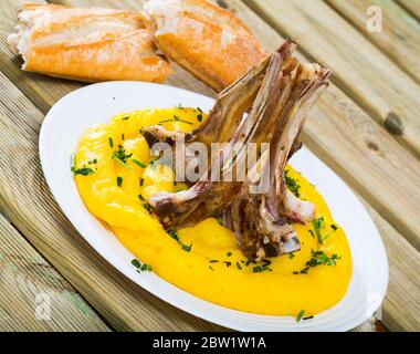 Délicieux agneau cuit sur l'os (Pinnekjott) servi avec une purée de rutabaga, de vert et de pain frais. Une cuisine norvégienne Banque D'Images