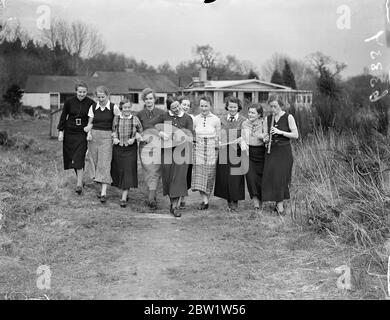 Fräuleins dans la Nouvelle Forêt bon campera à Godshill. Les filles du mouvement de la jeunesse d'Hitler - étudiants, commis et mains d'usine entre les âges de 18 et 25 - assistent à un deuxième camp annuel organisé pour promouvoir l'amitié anglo - allemande à Godshill dans la New Forest dans le Hampshire. Ils doivent divertir une fête de filles anglaises pendant le week-end. De jeunes filles d'Angleterre vont dans un camp similaire en Allemagne. Photos: Les filles allemandes marchant dans la Nouvelle forêt avec leur mandoline. 10 avril 1937 Banque D'Images