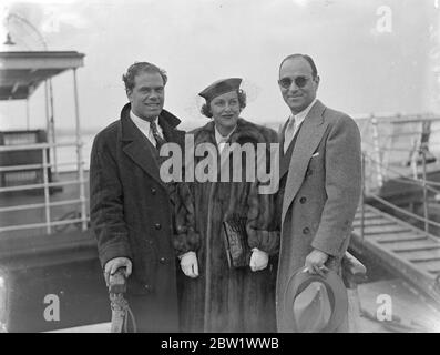 Frank Capra et sa femme sont arrivés pour le premier ministre de Lost Horizon. M. Frank Capra, le réalisateur hollywoodien accompagné de Mme Capra et M. Robert Riskin, collaborateur de l'écrivain, sont arrivés à Southampton sur la Normandie pour assister à la première de 'The Lost Horizon' et du Tivoli à Londres. Séances photo, M. et Mme Frank Capra et M. Robert Riskin à leur arrivée à Southampton. 19 avril 1937 Banque D'Images