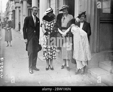 Duchesse de Kent revient avec son enfant de la baptême. La duchesse de Kent était une marraine au baptême dans la chapelle du palais de Lambeth de la fille de Lord et de Lady Herbert. Le bébé a reçu les noms Diana Mary. Ses deux parents sont membres de la maison du duc de Kent. Lord Herbert est Echéry au Duc et Lady Herbert est petite dame en attente à la Duchesse. Spectacles de photos, la duchesse de Kent, qui porte une mode d'été, avec Lord et Lady Herbert et le bébé à leur retour à la maison de Lord Herbert Eaton Square après le baptême. 1er juin 1937 Banque D'Images