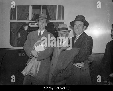 Perry revient pour faire la première apparition professionnelle en Angleterre. Arrivée avec Vines d'Amérique. Fred Perry, ancien joueur de tennis amateur numéro un mondial, est arrivé à la gare de Paddington à bord du train Europa avec Ellsworth Vines, l'américain avec lequel il fera sa première apparition professionnelle en Angleterre. Perry et VINES viennent de conclure une série de matchs professionnels en Amérique. Spectacles photo, Fred Perry avec son père, et Ellsworth Vines à l'arrivée à Paddington. 21 mai 1937 Banque D'Images
