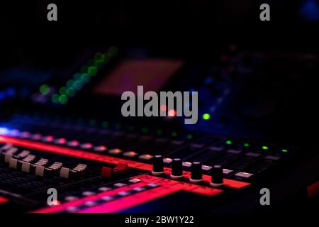 Console de mixage audio avec bandes colorées dans un faible éclairage dans une salle de concert Banque D'Images