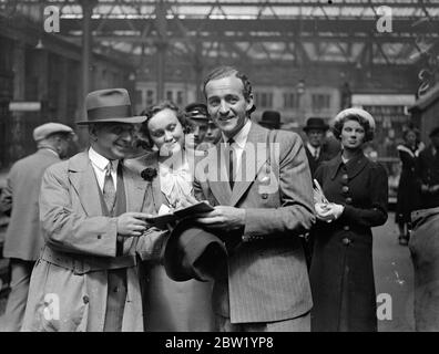 David Niven arrive d'Amérique, la « cystery » de l'engagement. David Niven, l'acteur britannique du cinéma, qui ne confirmera ni ne nie les rumeurs de son engagement envers Merle Oberon, est arrivé à Londres depuis l'Amérique sur le train 'Normandie'. Fils du regretté gén William Graham Niven et du regretté Lady Comyn Platt, Niven a conçu une commission dans le Highland Light Infantry lors d'une carrière à Stowe et Sandhurst. Après une période de globetrotting, il a été offert un test d'écran à Hollywood. Expositions de photos, David Niven, signant des autographes à l'arrivée à Waterloo. 21 juin 1937 Banque D'Images