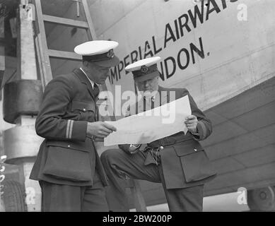 Le capitaine A. S. Wilcockson (à droite) et le premier officier G. H. Bowes étudient la route de l'Atlantique à Hythe, Southampton, à côté de Caledonia, en vue du premier passage transatlantique commercial expérimental effectué par le bateau volant Caledonia la semaine prochaine (24 juin). 18 juin 1937 Banque D'Images