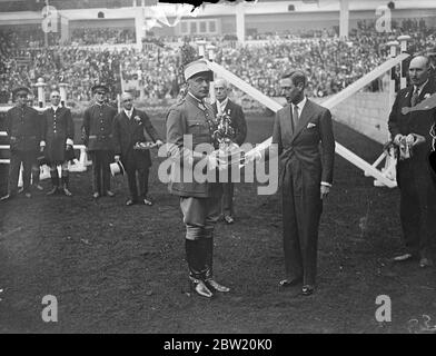 King présente la coupe d'or au champion Miller, Terry Horsman à Olympia. Le seul participant français gagne. Le Roi, qui a assisté au spectacle international du Cheval avec la Reine et les Princesses, a présenté la coupe d'or du Roi George V au Capitaine Xavier Bizard, de l'École de Cavalerie de Saumur, en France, le seul participant français, à Olympia. La coupe a été sautée par les officiers militaires de nombreuses nations. Spectacles photo, le roi a présenté la coupe d'or du roi George V au Capt Bizard. 24 juin 1937 Banque D'Images