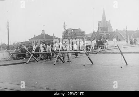 Cette photo, qui vient d'être reçue de Shanghai à Londres, montre une scène effrayante dans le Grand monde, le centre d'amusement de Shanghai, dans lequel 800 personnes ont été tuées lors d'un raid aérien. Le carnage et la ruine terribles ont été introduits dans la ville par le bombardement aérien et d'artillerie continu alors que les Japonais se sont lentement fermés. Des corps mutilés étaient éparpillés partout dans le parc. Des barricades en fil barbelé sont lancées sur le pont de Museum Road, qui divise le quartier de Hongkew de la partie centrale de la colonie internationale de Shanghai. Les réfugiés chinois tentent de pénétrer dans la rue, mais ils ont été détournés Banque D'Images