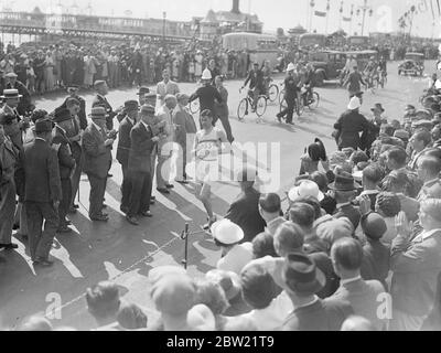 Harold Whitlock, champion olympique et vainqueur des trois dernières années, finissant la course à Brighton. Après avoir concourir dans la marche annuelle de Londres à Brighton organisée par le club de marche de Surrey. Il a parcouru le parcours de 52 miles en huit heures, deux minutes et 36 secondes. Avec George Cummings, champion des Britanniques Guians, qui est venu 4000 miles pour concourir et E.A. Jury du club de sport Southdown Motors. 4 septembre 1937. Banque D'Images