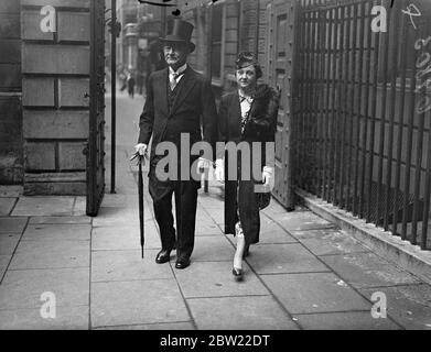 Sir Holman Gregory va à Old Bailey pour le dernier jour comme enregistreur de Londres. Sir Holman Gregory, KC, 73 ans, registraire de Londres, est allé au Old Bailey pour ce qui est probablement sa dernière séance. On s'attend à ce que son dernier cas, un cas de chantage présumé, bien, se termine aujourd'hui (mardi). Sir Holman est connu, et aimé par les anciens détenus, pour la main d'aide. Il s'étend à beaucoup pour les criminels qu'il a condamnés. Photos, Sir Holman Gregory, KC, quitte son bureau au Temple du milieu, accompagné de sa femme pour sa dernière journée au Old Bailey. 28 septembre 1937. Banque D'Images