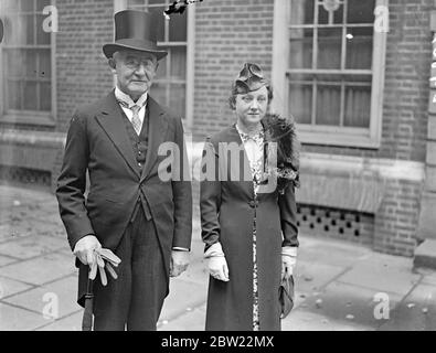 Sir Holman Gregory va à Old Bailey pour le dernier jour comme enregistreur de Londres. Sir Holman Gregory, KC, 73 ans, registraire de Londres, est allé au Old Bailey pour ce qui est probablement sa dernière séance. On s'attend à ce que son dernier cas, un cas de chantage présumé, bien, se termine aujourd'hui (mardi). Sir Holman est connu, et aimé par les anciens détenus, pour la main d'aide. Il s'étend à beaucoup pour les criminels qu'il a condamnés. Photos, Sir Holman Gregory, KC, quitte son bureau au Temple du milieu, accompagné de sa femme pour sa dernière journée au Old Bailey. 28 septembre 1937. Banque D'Images