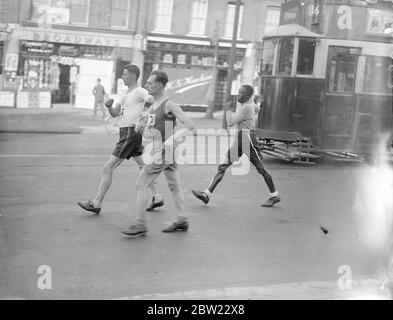 Harold Whitlock (à gauche) le champion olympique et vainqueur des trois dernières années, dirigé à Streatham Common dans la promenade annuelle de Londres à Brighton organisée par le club de marche de Surrey. Avec George Cummings, champion de la Guyane britannique, qui a parcouru 4000 miles pour participer et E.A. Jury du club de sport Southdown Motors. 4 septembre 1937. Banque D'Images